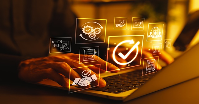 Person using a laptop with glowing digital compliance and verification icons floating above the keyboard, including checkmarks, security symbols, analytics charts, and handshake graphics in an orange-toned futuristic interface